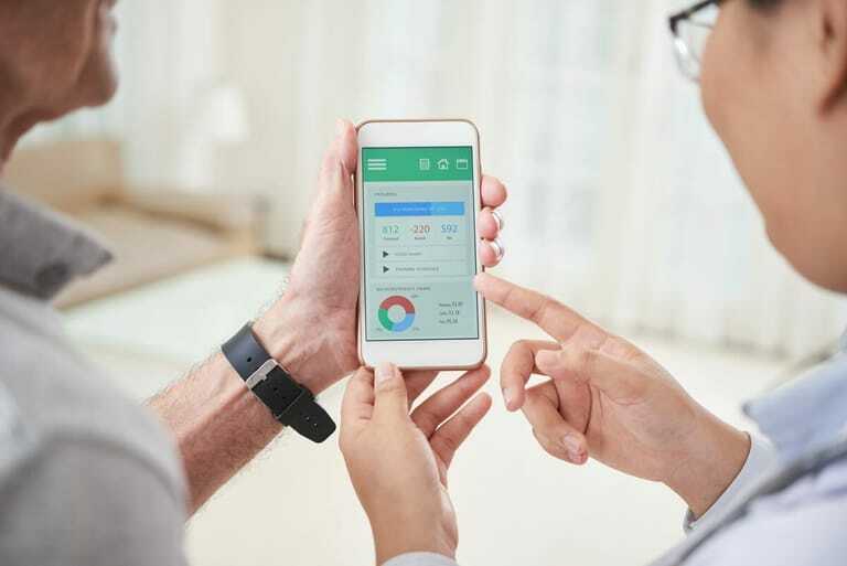 Arzt und Patienten sehen zusammen in ein Smartphone